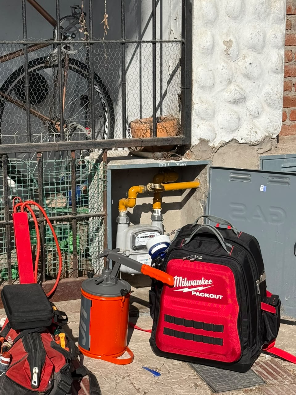 Herramientas de gasista junto a un medidor de gas en un trabajo